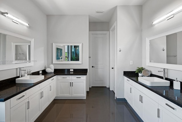 full bath with tile patterned flooring, visible vents, two vanities, and a sink