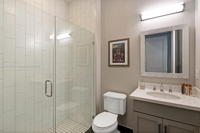 bathroom with toilet, a stall shower, and vanity