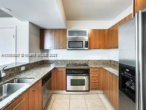 9066 SW 73rd Ct Unit 1002, Miami, FL 33156 - kitchen featuring stainless steel appliances, brown cabinetry, and a sink