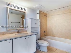 bathroom with vanity, tile patterned floors, toilet, and shower / tub combination