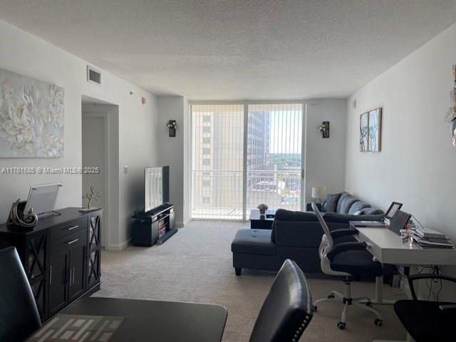 living room with a wall of windows, visible vents, carpet floors, and a textured ceiling