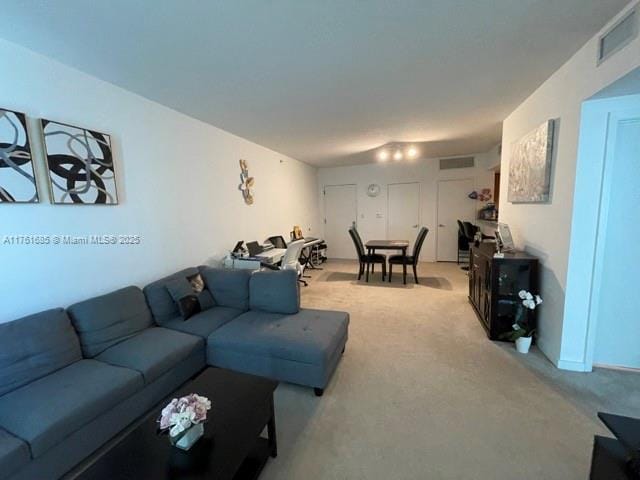 living area featuring visible vents and light colored carpet