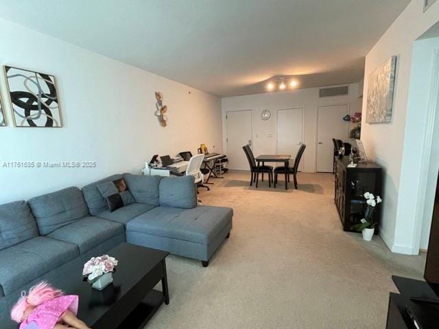 living area featuring visible vents and light colored carpet