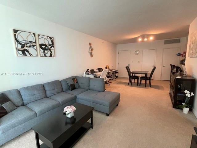 living room featuring visible vents and light carpet