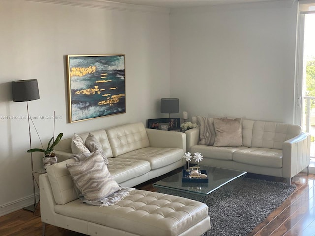 living area with baseboards, wood finished floors, and crown molding