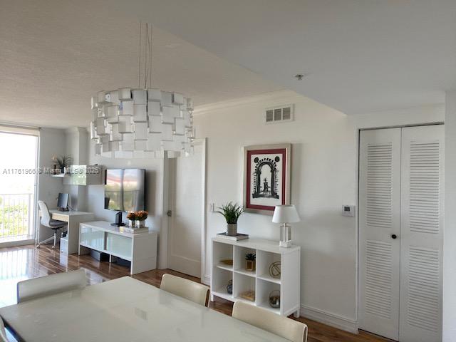 dining room with wood finished floors, visible vents, and baseboards