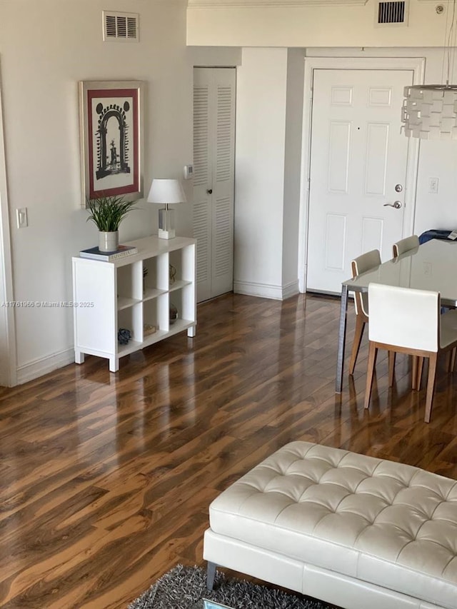 living room featuring wood finished floors, visible vents, and baseboards