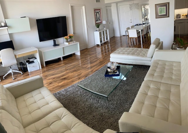 living area featuring visible vents and wood finished floors