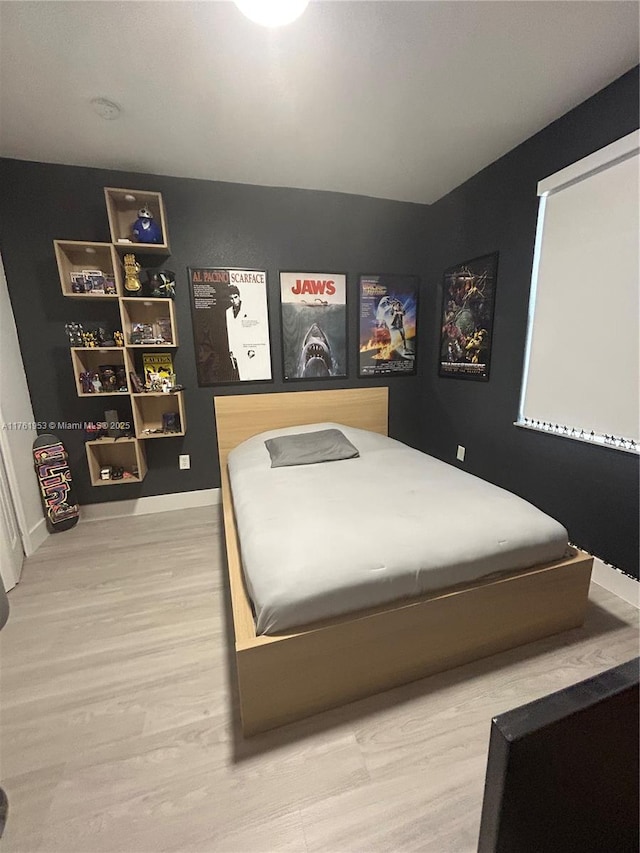 bedroom featuring wood finished floors and baseboards