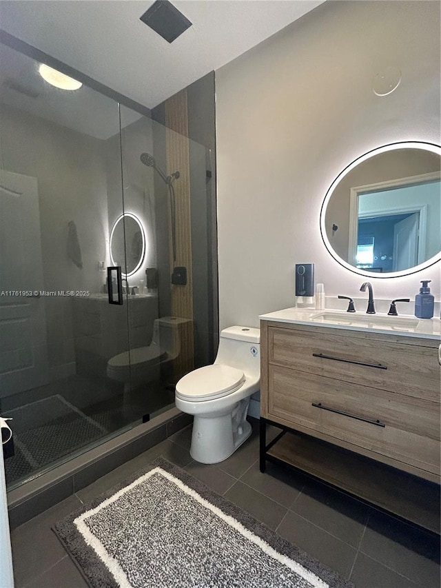 bathroom featuring tile patterned floors, toilet, a stall shower, and vanity