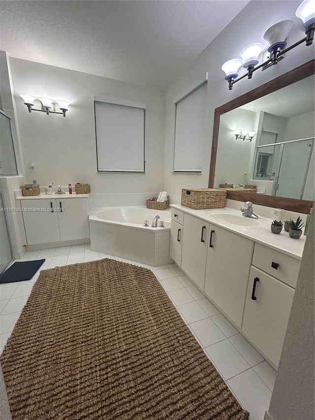 bathroom with a shower stall, a bath, tile patterned floors, a textured ceiling, and a sink