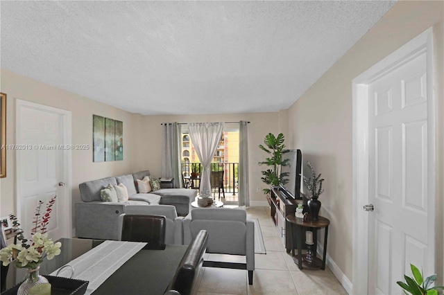 living room featuring light tile patterned flooring, baseboards, and a textured ceiling