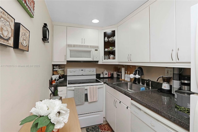 kitchen with white appliances, a sink, glass insert cabinets, white cabinetry, and dark countertops