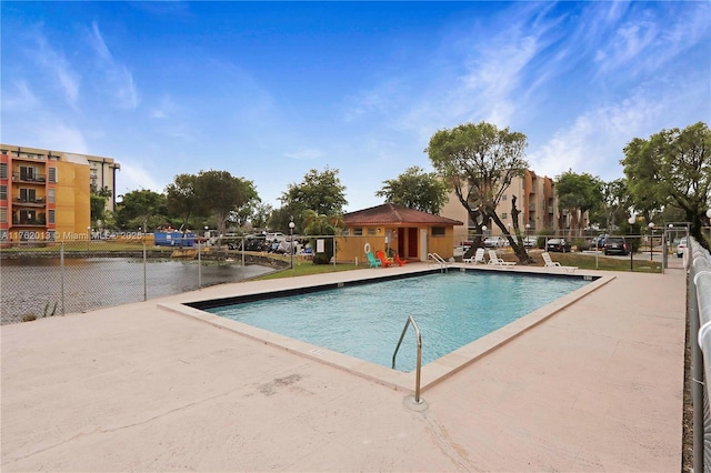 pool with a patio area and fence