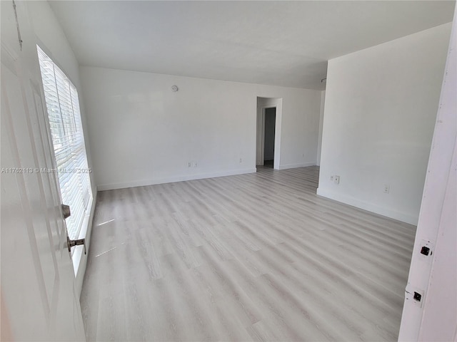 unfurnished room featuring baseboards and light wood finished floors