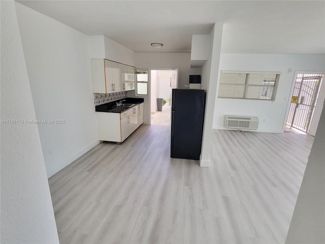 kitchen featuring plenty of natural light, backsplash, white cabinets, and light wood finished floors