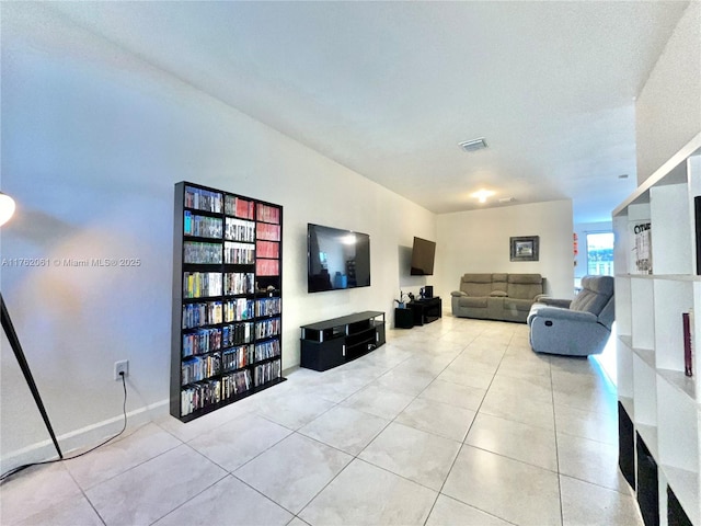 living room with light tile patterned floors, visible vents, and baseboards