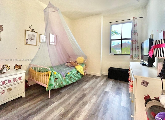 bedroom featuring baseboards and wood finished floors