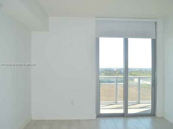 unfurnished room with baseboards