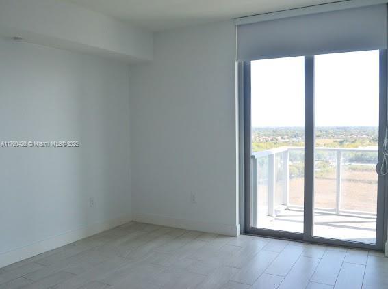 empty room featuring baseboards and plenty of natural light