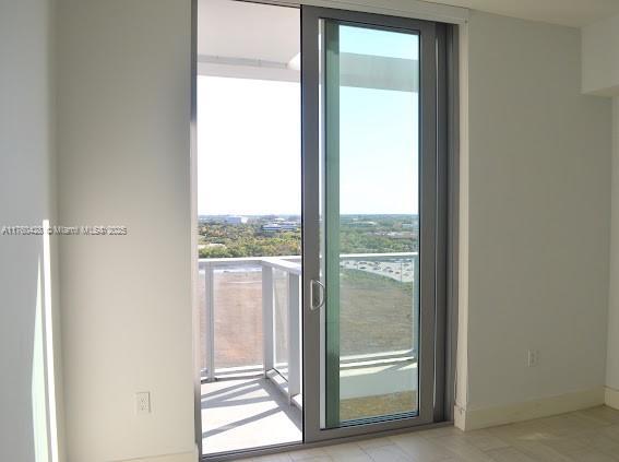 doorway to outside with baseboards