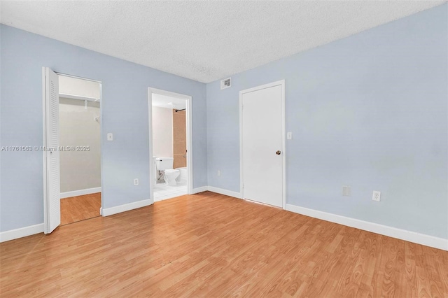 unfurnished bedroom with light wood finished floors, visible vents, and baseboards