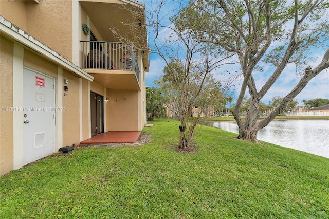 view of yard featuring visible vents, a water view, and a balcony