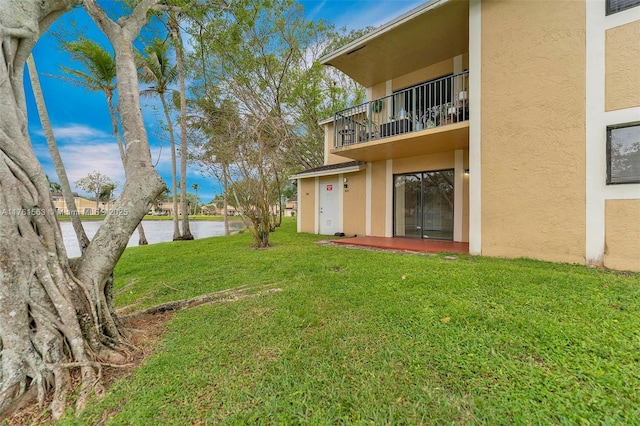 view of yard with a balcony and a water view