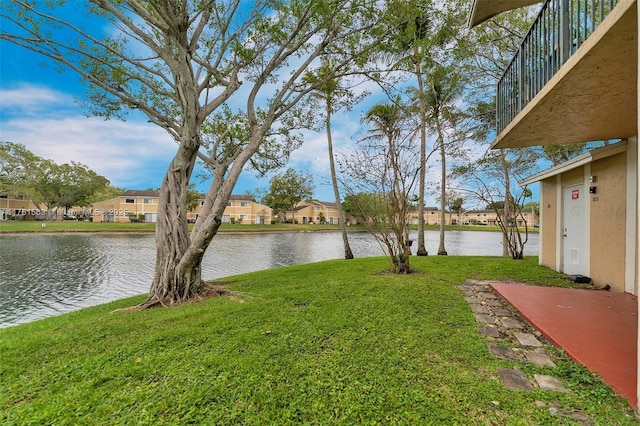 view of yard featuring a residential view and a water view