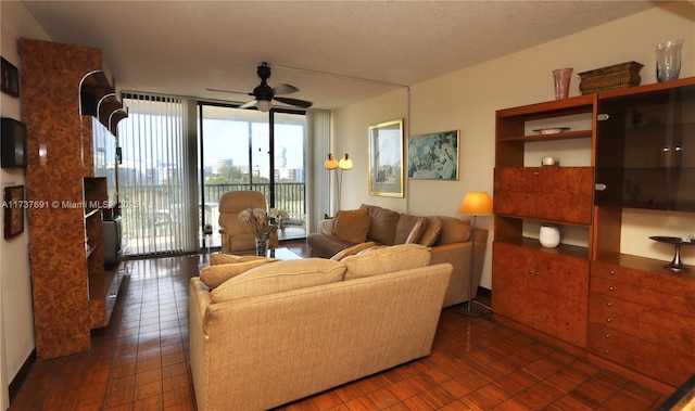 living room with a ceiling fan and expansive windows