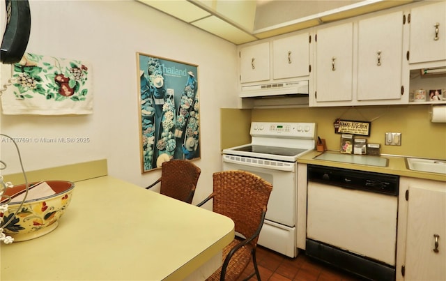 kitchen featuring white appliances, under cabinet range hood, and light countertops