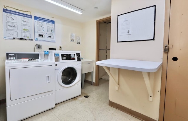 shared laundry area with baseboards, light floors, and washer and dryer
