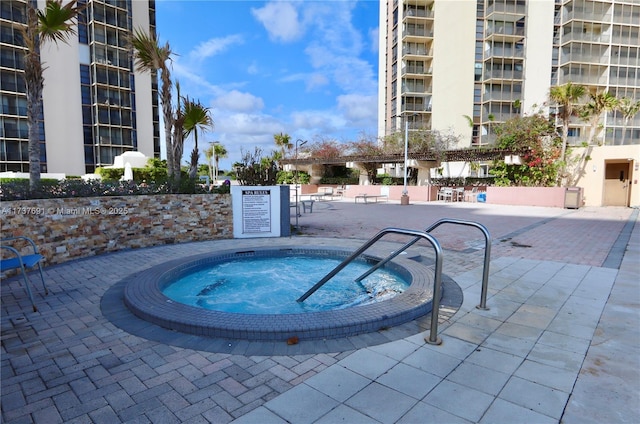 view of swimming pool with a hot tub