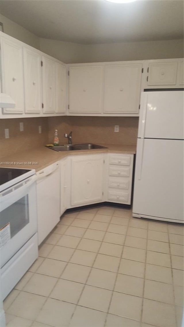 kitchen featuring a sink, white cabinetry, white appliances, light countertops, and light tile patterned floors