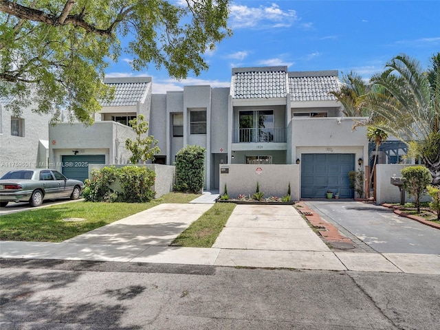 view of front of property with a balcony, stucco siding, concrete driveway, a garage, and a tile roof