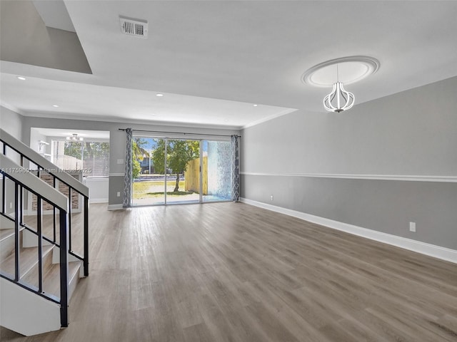 unfurnished living room featuring visible vents, wood finished floors, recessed lighting, baseboards, and stairs