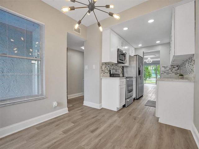 kitchen featuring light wood-type flooring, baseboards, visible vents, and stainless steel appliances