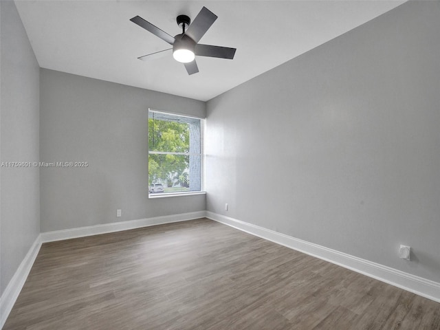 spare room featuring a ceiling fan, wood finished floors, and baseboards