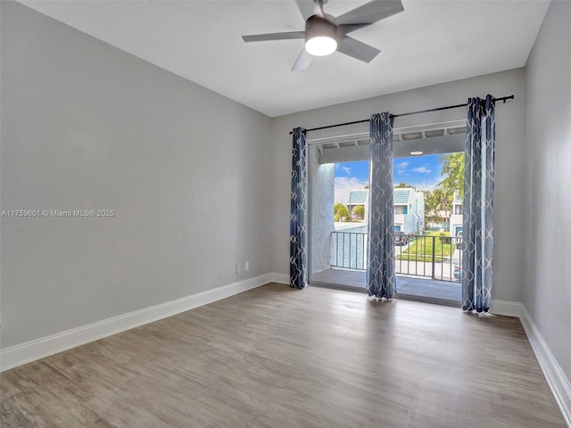 empty room featuring a ceiling fan, wood finished floors, and baseboards