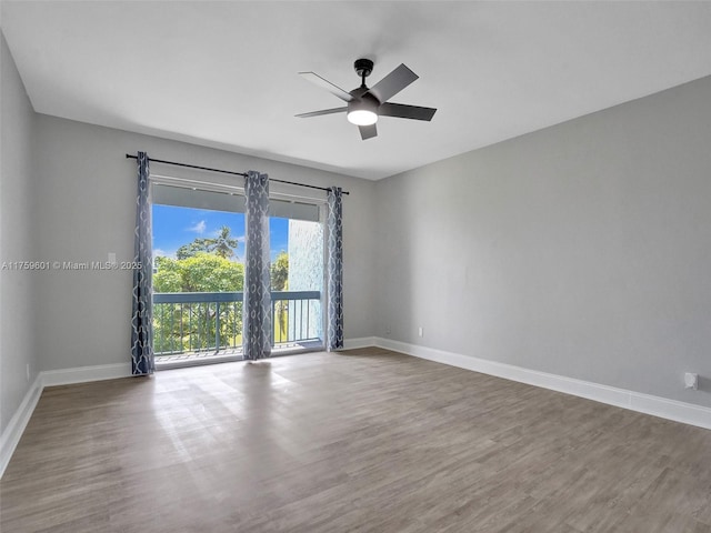 empty room featuring a ceiling fan, wood finished floors, and baseboards