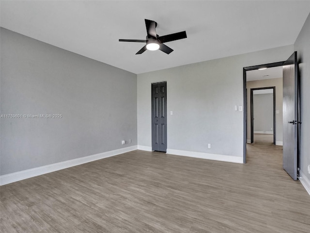 interior space featuring a ceiling fan, baseboards, and wood finished floors