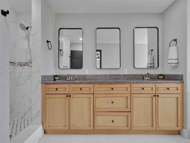 bathroom featuring double vanity, a marble finish shower, and a sink