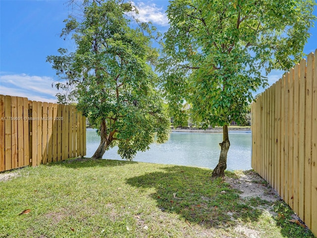 view of yard with a water view and fence