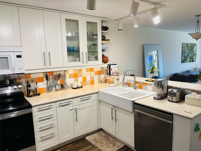 kitchen with stainless steel electric range oven, dishwashing machine, white microwave, a peninsula, and a sink