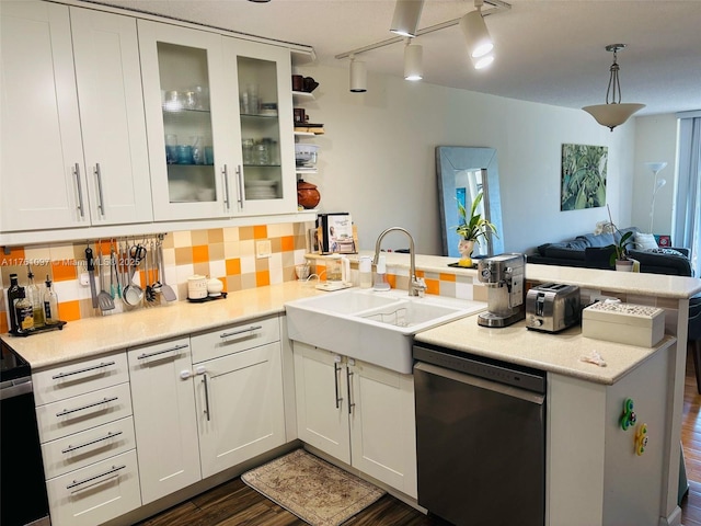 kitchen featuring a sink, tasteful backsplash, open floor plan, a peninsula, and dishwasher