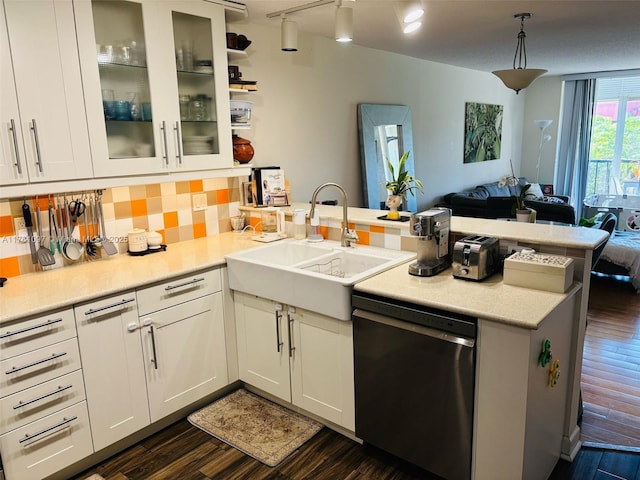 kitchen featuring dishwashing machine, a peninsula, a sink, open floor plan, and tasteful backsplash