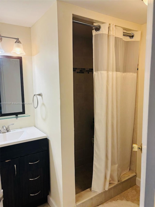 full bath featuring tile patterned floors, a stall shower, and vanity