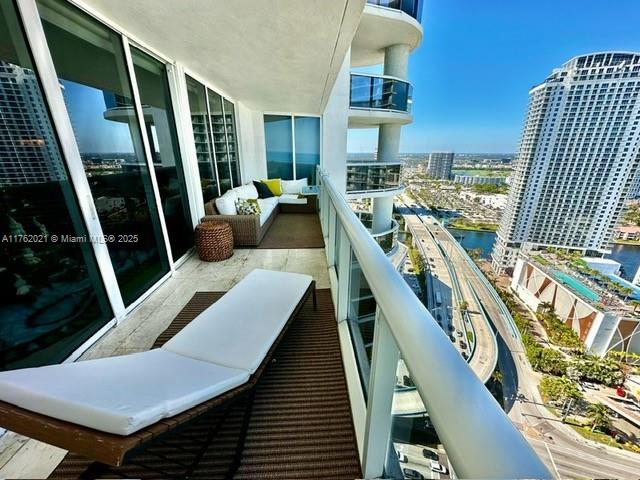 balcony with a water view, a city view, and outdoor lounge area