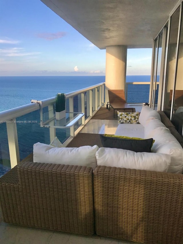 balcony featuring outdoor lounge area and a water view
