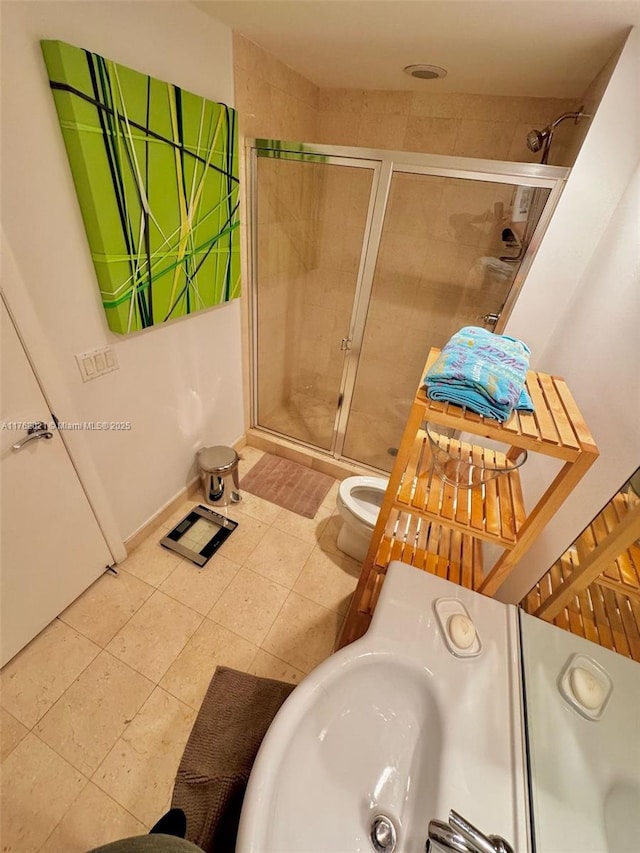 bathroom featuring toilet, tile patterned floors, and a shower stall